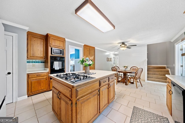 kitchen with a kitchen island, decorative backsplash, light tile patterned floors, stainless steel appliances, and crown molding