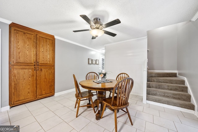 dining area featuring crown molding, light tile patterned flooring, ceiling fan, and a textured ceiling