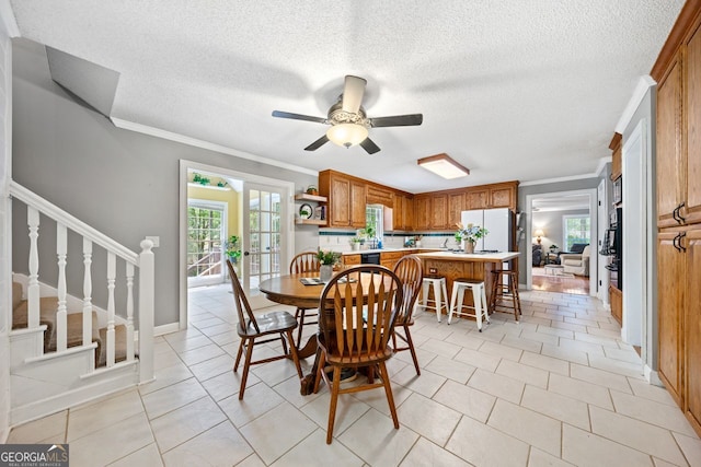 dining area with ornamental molding, plenty of natural light, light tile patterned floors, and ceiling fan