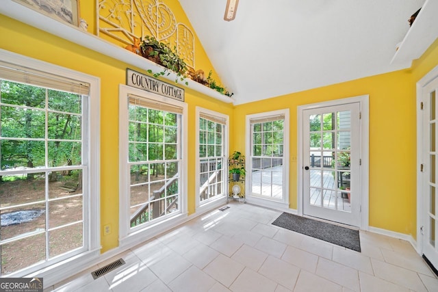 entryway featuring light tile patterned flooring, lofted ceiling, and plenty of natural light