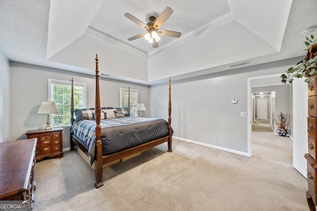 carpeted bedroom with ceiling fan, a tray ceiling, and a textured ceiling