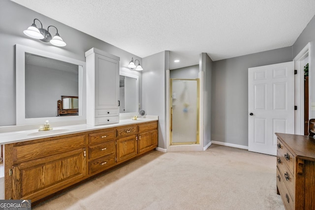 bathroom featuring vanity, a shower with shower door, and a textured ceiling