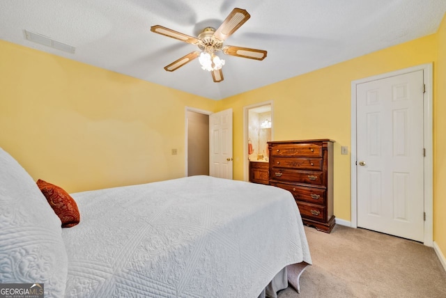 carpeted bedroom with ceiling fan and ensuite bathroom