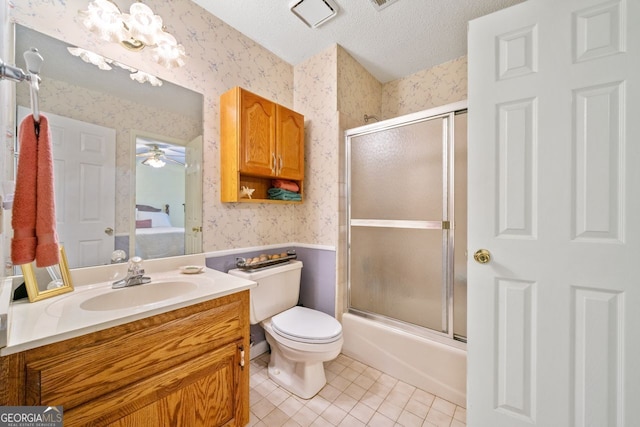 full bathroom featuring bath / shower combo with glass door, vanity, toilet, tile patterned floors, and a textured ceiling