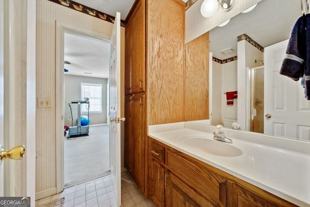 bathroom featuring walk in shower, tile patterned floors, a textured ceiling, and vanity