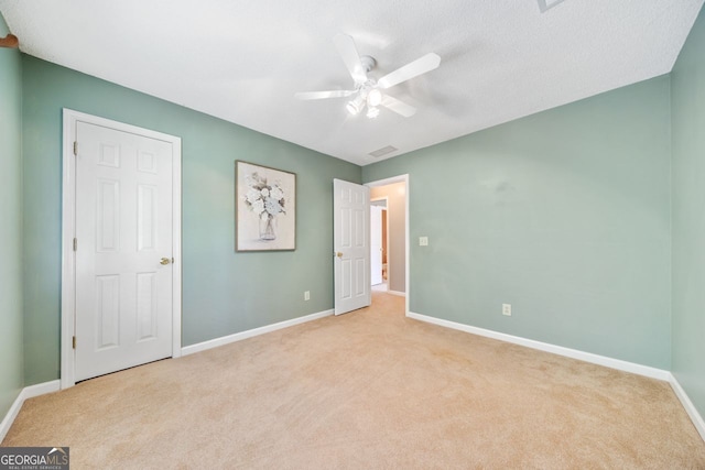 unfurnished bedroom with light carpet and ceiling fan