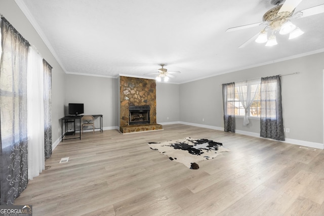 living room featuring a fireplace, ornamental molding, ceiling fan, and light wood-type flooring