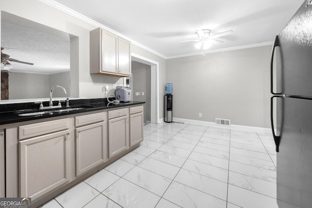 kitchen featuring black fridge, ceiling fan, crown molding, and sink