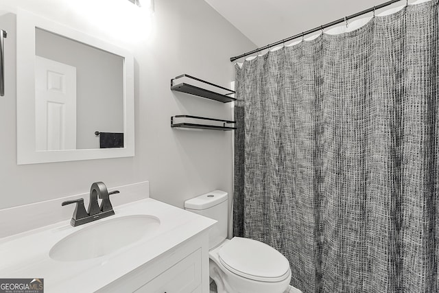 bathroom with vanity, curtained shower, and toilet