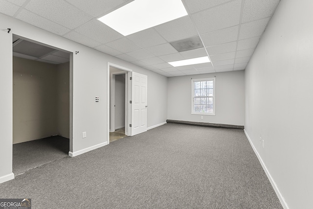 spare room featuring a drop ceiling, baseboard heating, and carpet