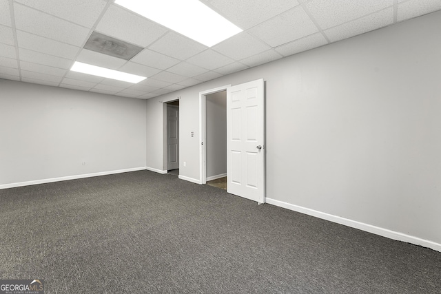 interior space featuring a paneled ceiling and dark carpet