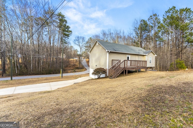 view of home's exterior with a deck and a lawn