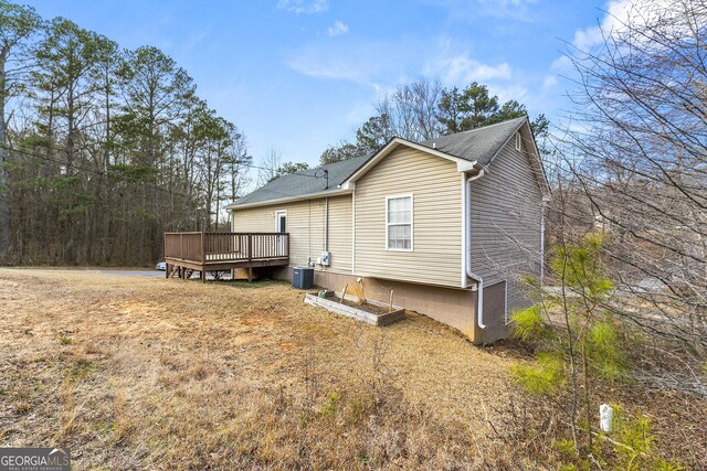 back of property featuring a yard, central air condition unit, and a deck