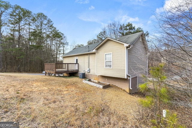 back of property with a wooden deck and central AC unit