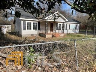 bungalow-style home featuring a fenced front yard and crawl space