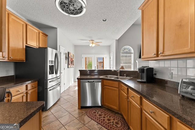 kitchen with sink, light tile patterned floors, dishwasher, ceiling fan, and backsplash