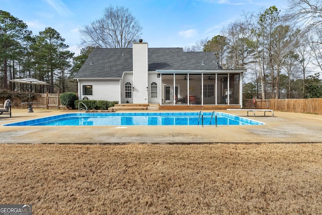 view of pool featuring a patio, a diving board, a lawn, ceiling fan, and a sunroom