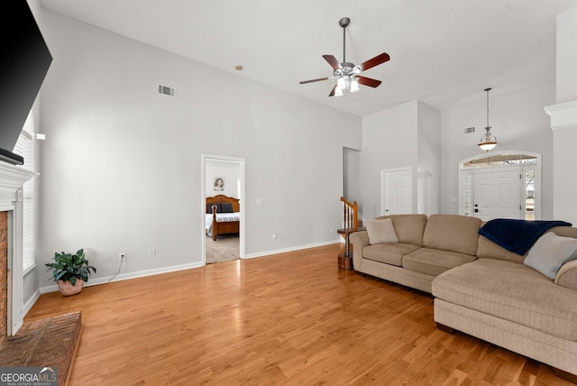 living room featuring ceiling fan, high vaulted ceiling, and light hardwood / wood-style flooring