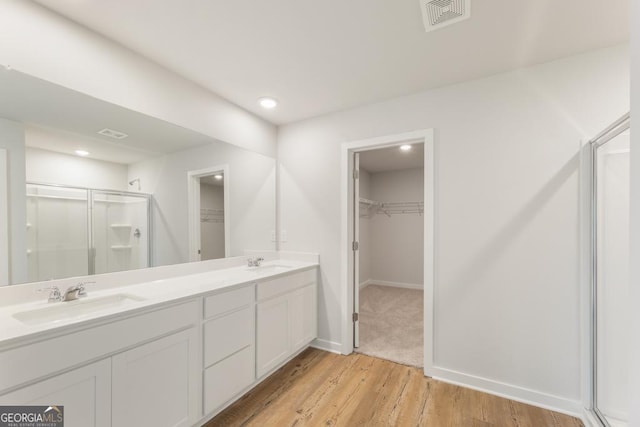 bathroom featuring vanity, hardwood / wood-style flooring, and a shower with shower door