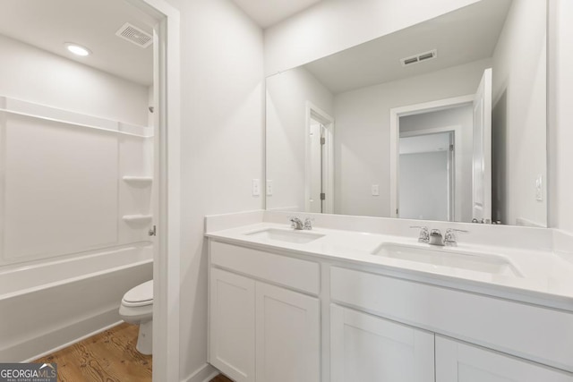 full bathroom featuring shower / tub combination, vanity, hardwood / wood-style floors, and toilet