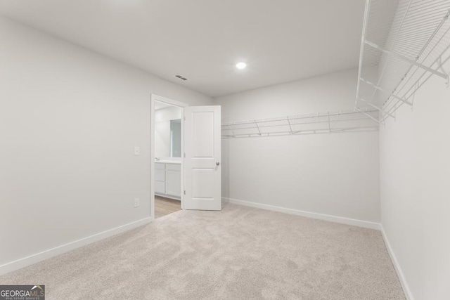 spacious closet featuring light carpet