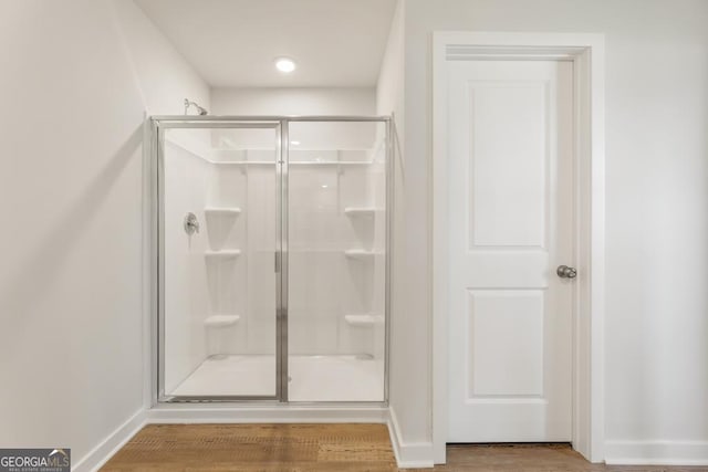 bathroom featuring a shower with door and hardwood / wood-style floors