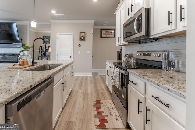 4738 Cypress Park Dr SW, Gainesville, GA 30504 - kitchen with appliances with stainless steel finishes, ornamental molding, light wood finished floors, decorative backsplash, and white cabinetry