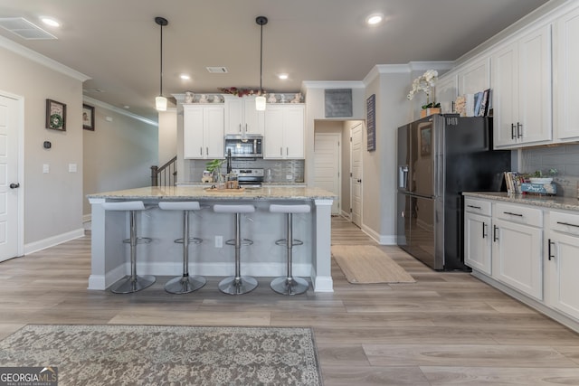 kitchen with pendant lighting, light stone countertops, and white cabinets