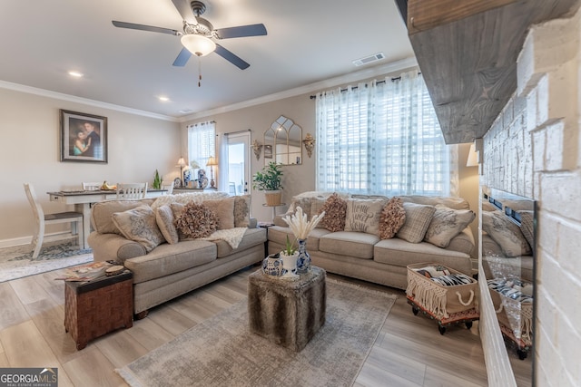 living room featuring ornamental molding, ceiling fan, and light hardwood / wood-style flooring