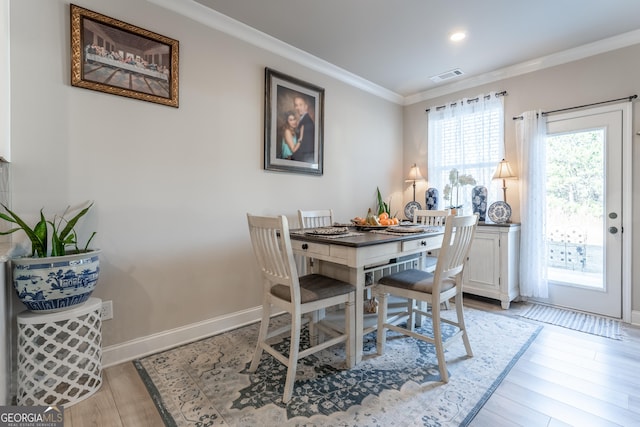 dining room with light hardwood / wood-style flooring and ornamental molding