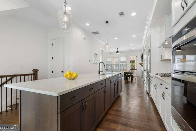 kitchen featuring a spacious island, decorative light fixtures, stainless steel appliances, and white cabinets