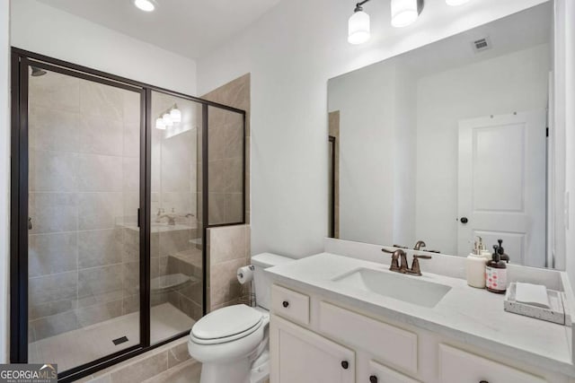 bathroom featuring vanity, toilet, and an enclosed shower