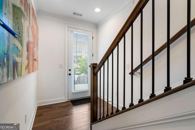 entrance foyer with ornamental molding and dark hardwood / wood-style flooring