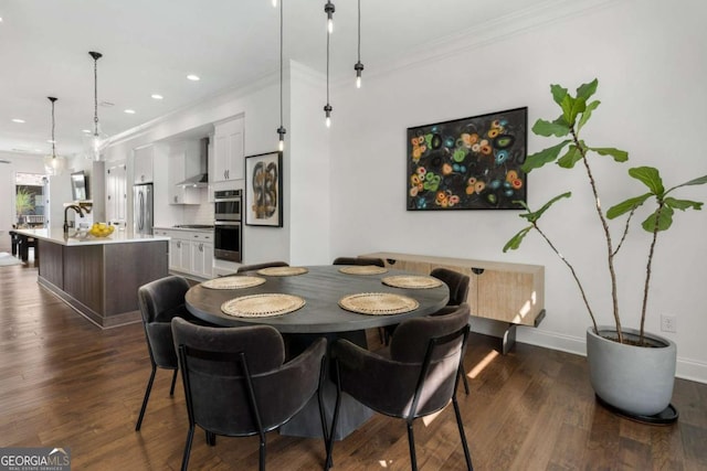 dining room featuring crown molding, dark wood-type flooring, and sink