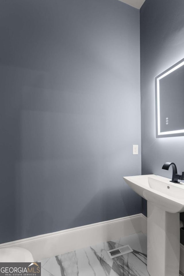 bathroom with marble finish floor, visible vents, and baseboards