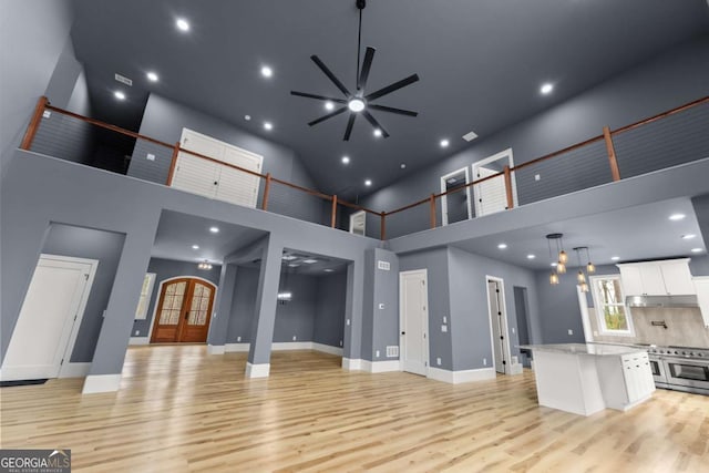 living area featuring light wood-type flooring, a healthy amount of sunlight, baseboards, and french doors