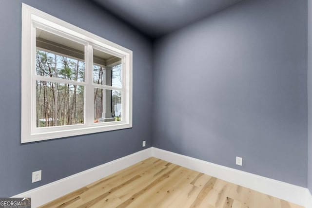 empty room featuring wood finished floors and baseboards