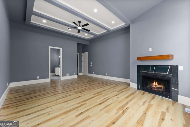 unfurnished living room featuring light wood-style flooring, baseboards, and a tile fireplace