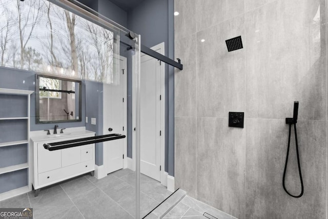 bathroom featuring walk in shower, vanity, and tile patterned floors