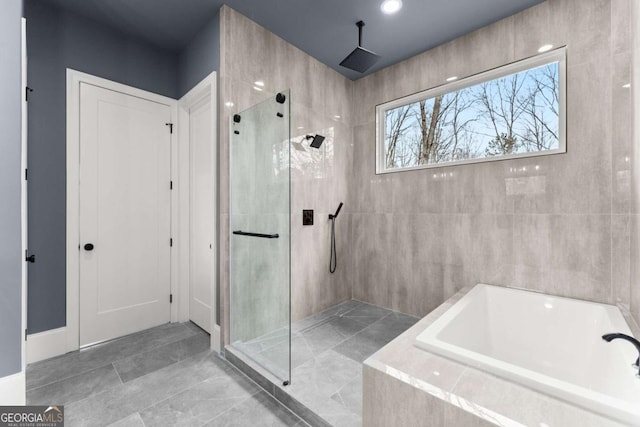 bathroom featuring a shower stall and a bath