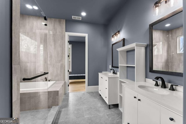 bathroom featuring two vanities, visible vents, a sink, a tile shower, and a bath