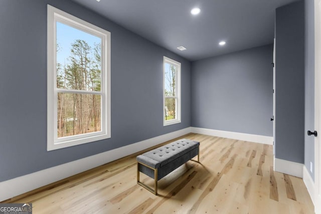 living area with baseboards, recessed lighting, and light wood-style floors