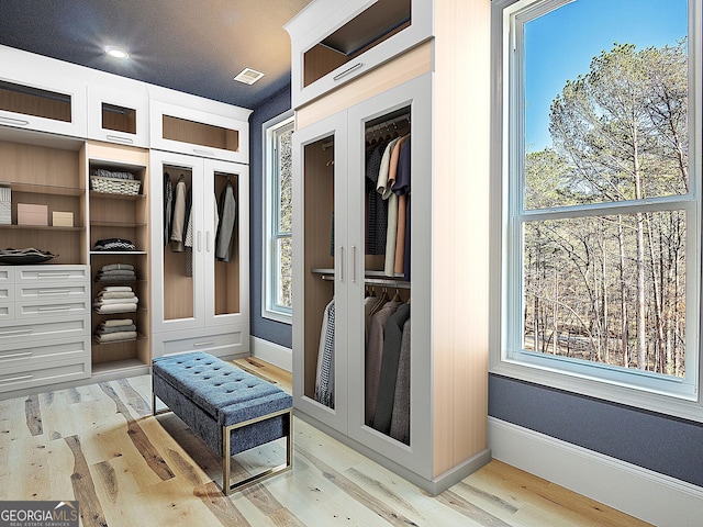 mudroom with light wood-type flooring, visible vents, and a healthy amount of sunlight