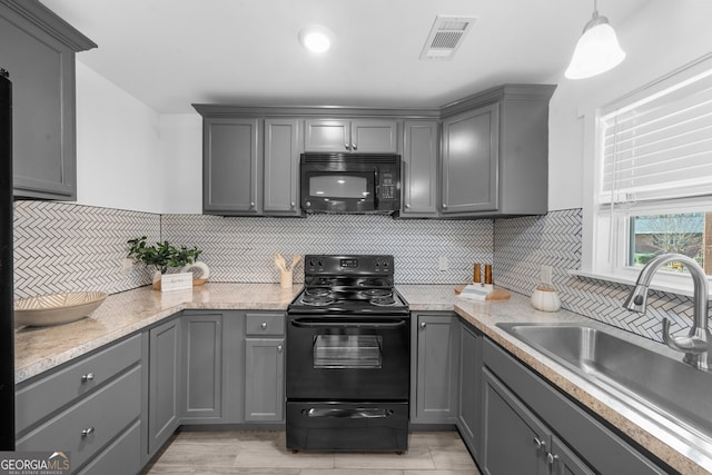 kitchen featuring gray cabinets, sink, decorative light fixtures, and black appliances