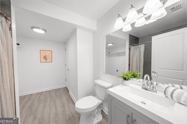 bathroom with vanity, toilet, and hardwood / wood-style floors