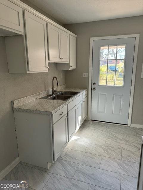 kitchen featuring sink and white cabinets