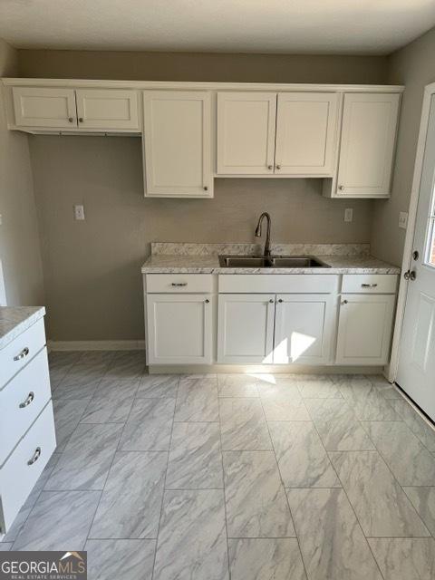 kitchen with white cabinetry and sink