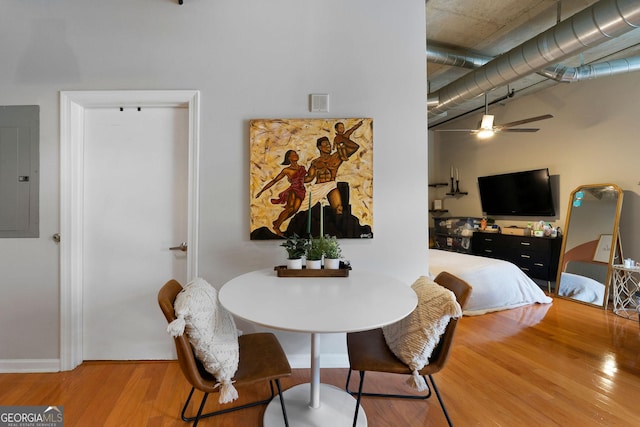 dining room with wood-type flooring, electric panel, and ceiling fan