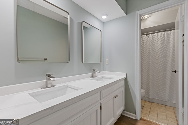 bathroom featuring vanity, curtained shower, and toilet