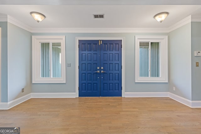 foyer entrance featuring ornamental molding and light hardwood / wood-style floors